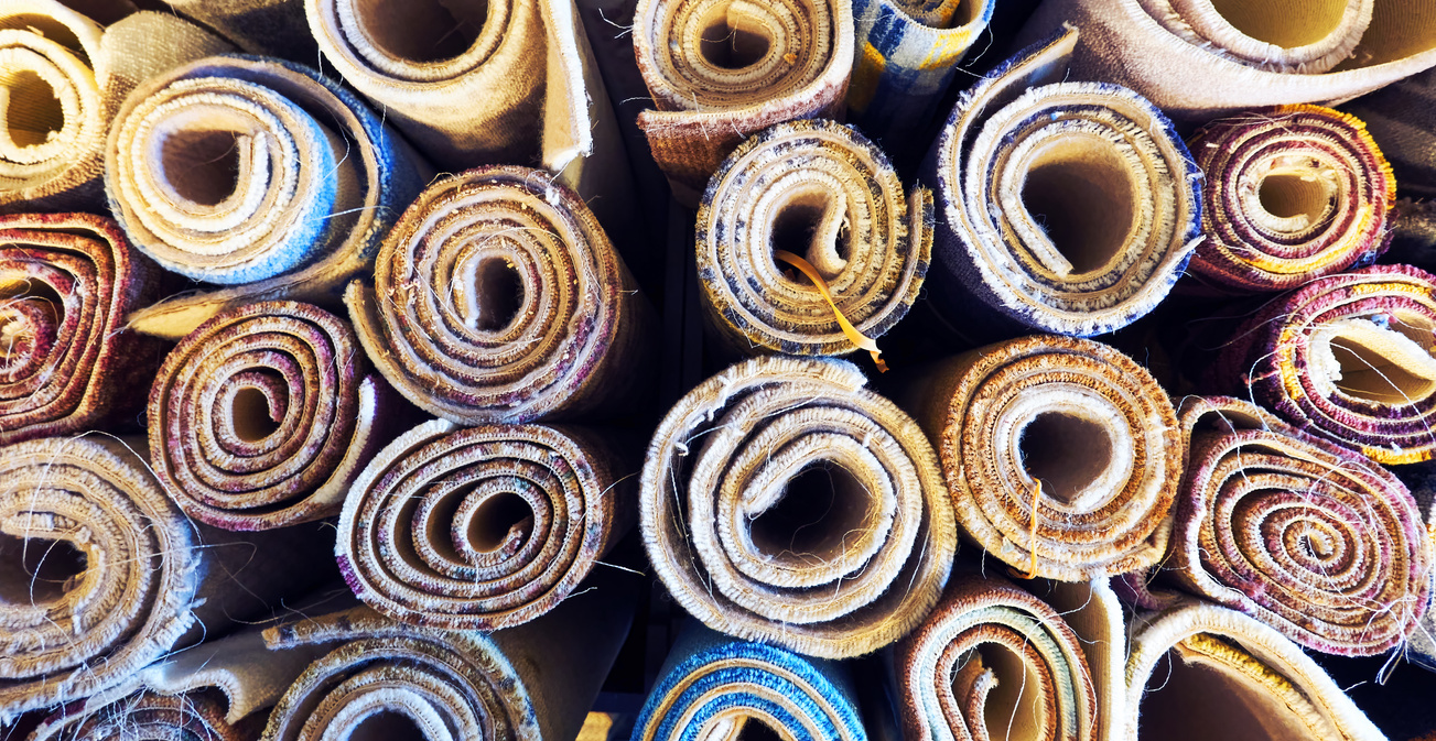 Variety of colorful carpets rolled up for display in a carpet store